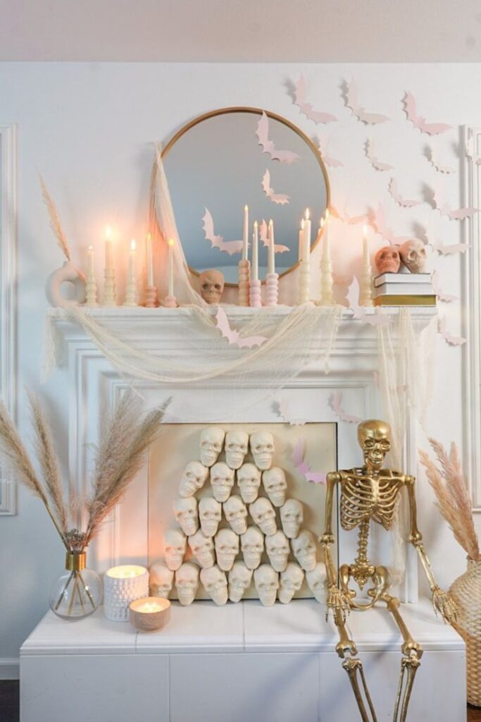 DIY white and gold Halloween decor featuring bats, skeletons, and candles